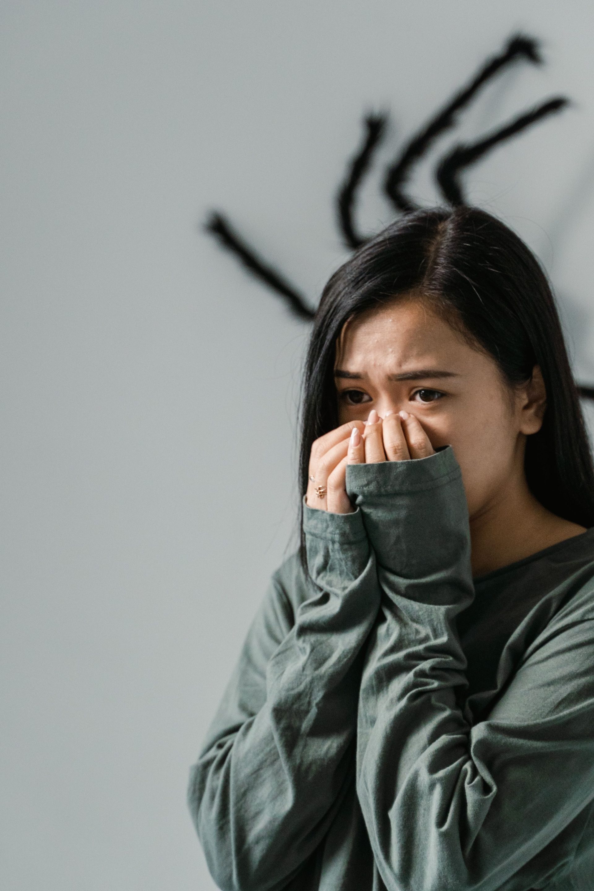 Young woman showing fear due to spider, illustrating anxiety and phobia.